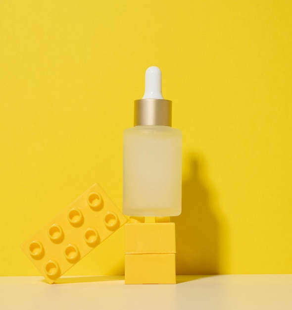 White glass transparent bottle with a pipette for cosmetics oils acids on a white table