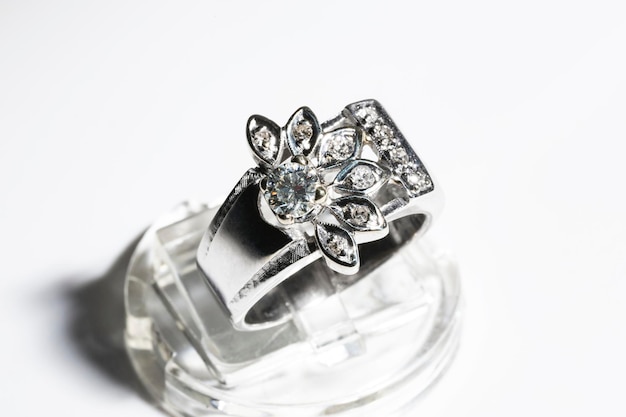 White gold diamond ring on a white background floral theme at the rim