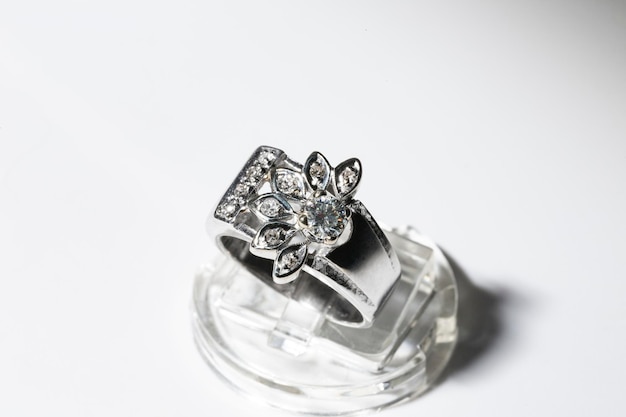 White gold diamond ring on a white background floral theme at the rim