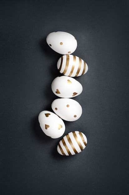 White and gold easter eggs on black background