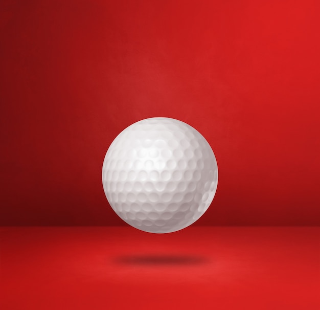 White golf ball isolated on a red studio background. 3D illustration