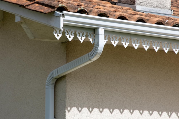 White gutter guard system roof drip edge with design decoration under roof on modern home neighborhood