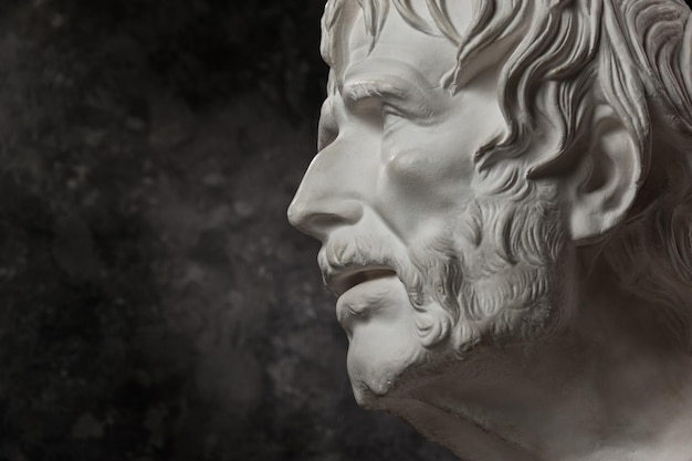 White gypsum copy of ancient statue of Lucius Seneca head for artists on a dark textured background. Seneca 4 BC-65 AD Roman stoic philosopher, statesman and tutor to the future Emperor Nero.