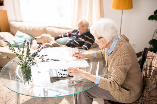 White Haired Woman Calculating Taxes