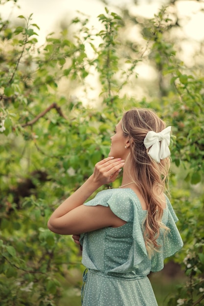 White hairpin bow on women's hair back view in blooming garden