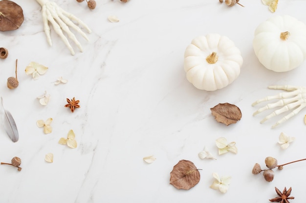 White halloween pumpkins with decor on marble background