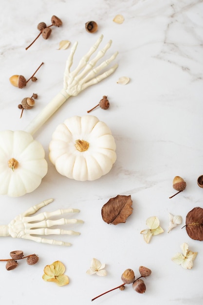 White halloween pumpkins with decor on marble background