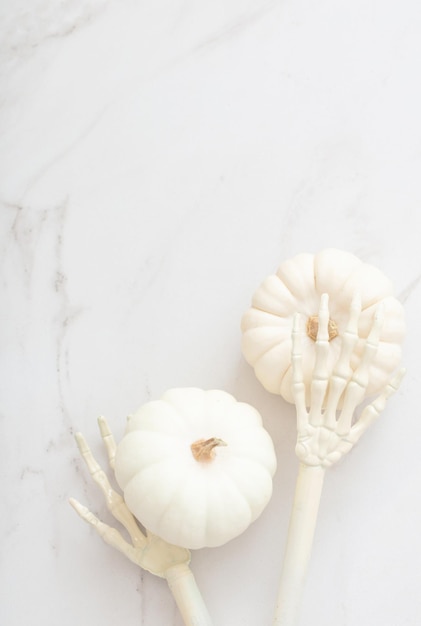 White halloween pumpkins with decor on marble background