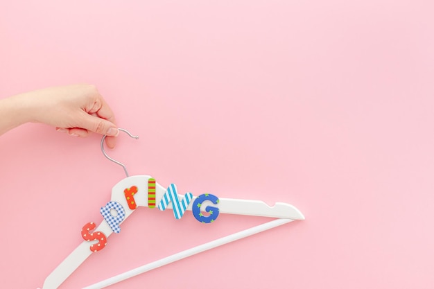 Photo white hangers with sale text on pink background