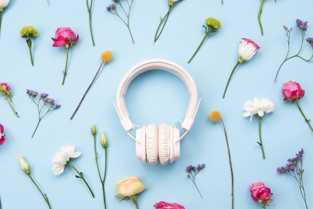 Photo white headphones on a floral, music concept