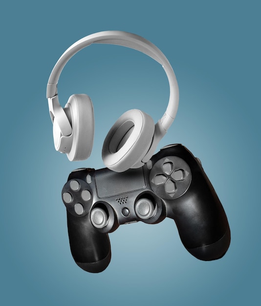 white headphones and gadget for computer games on a blue background