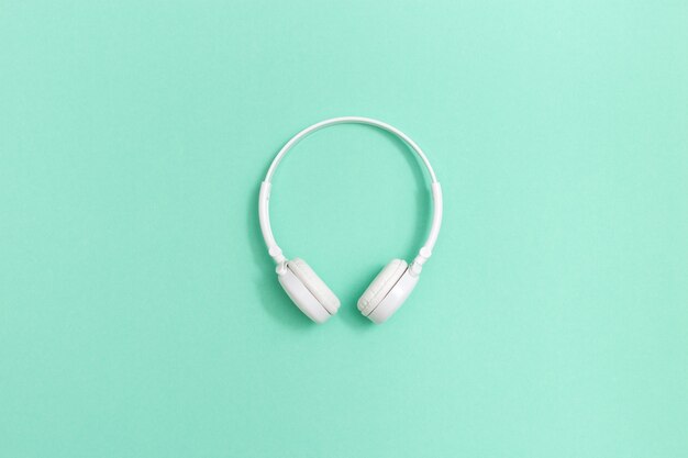 White headphones on mint colored paper