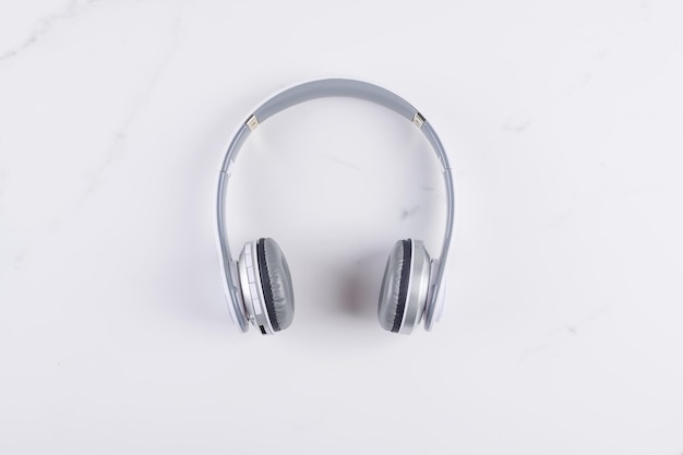 White headphones top view on white marble background with copy space