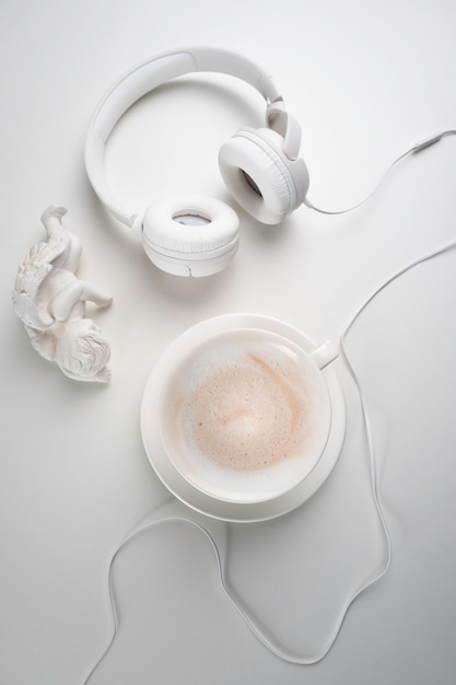 White headphones and a white cup on a white table