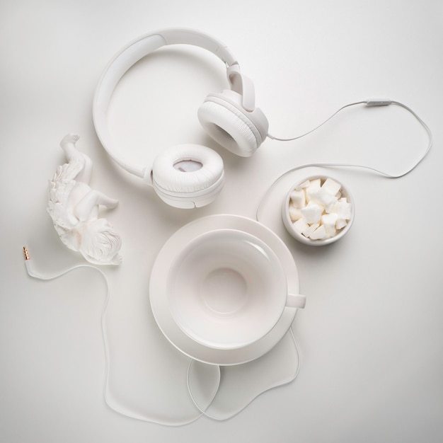 White headphones and a white cup on a white table