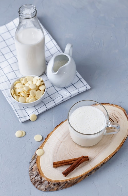 White hot chocolate and cinnamon on a wooden stand on a gray surface. Healthy breakfast concept. Keto drinks.