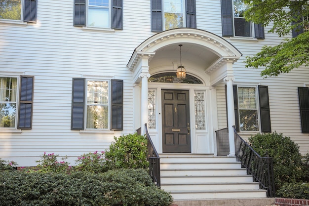 A white house with a black door and black shutters.