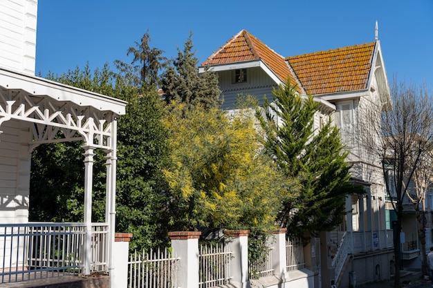 A white house with a porch and a yellow roof