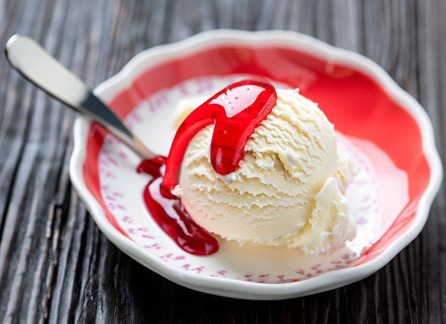 White ice cream scoop in a bowl with red syrup and a spoon ai generated