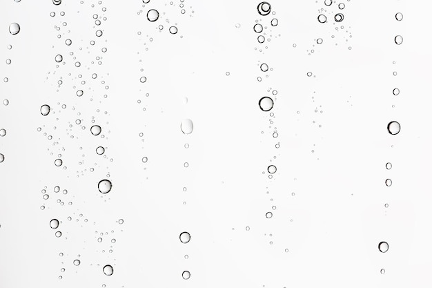 white isolated background water drops on the glass / wet window glass with splashes and drops of water and lime, texture autumn background