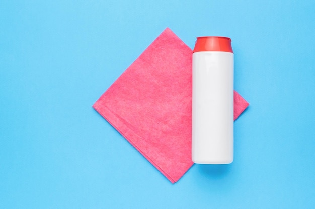 A white jar with cleaning agent and a red cleaning cloth on a blue background Cleaning kit