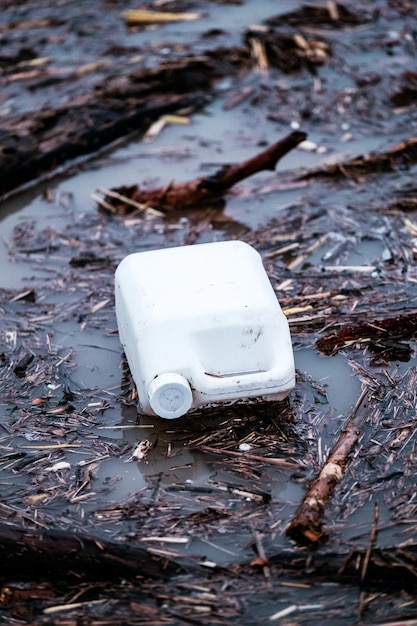 A white jerry can floating on the water in a flooding