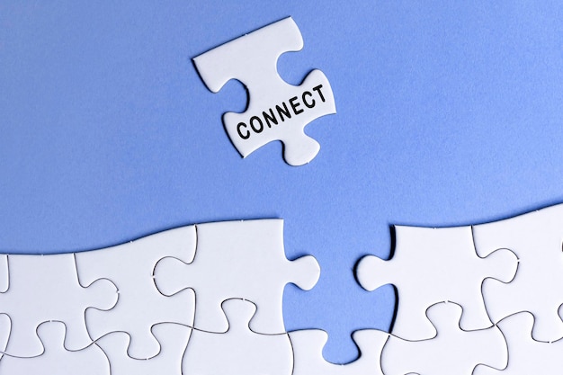 Photo white jigsaw puzzle with word connect over blue background relationship concept