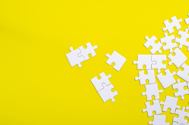 White jigsaw puzzle on a yellow background