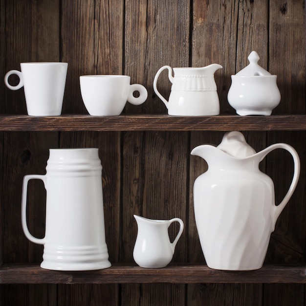 White kitchen dishware on old dark wooden background