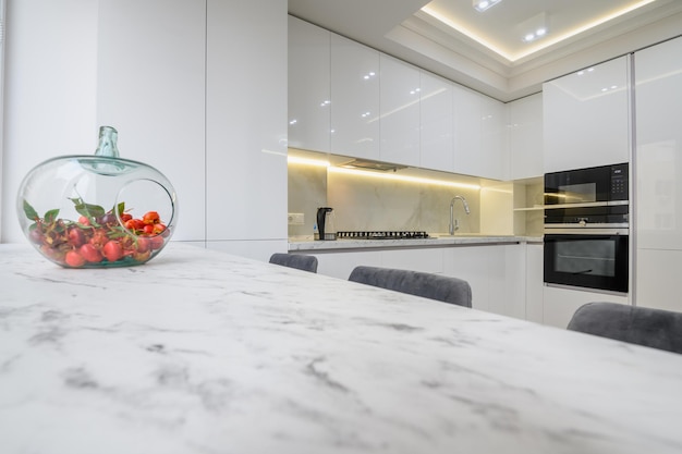 White kitchen interior a vase with fruits at marble counter top