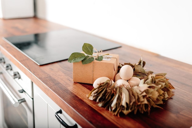 White kitchen with eggs and gift box Happy easter card with wooden eggs