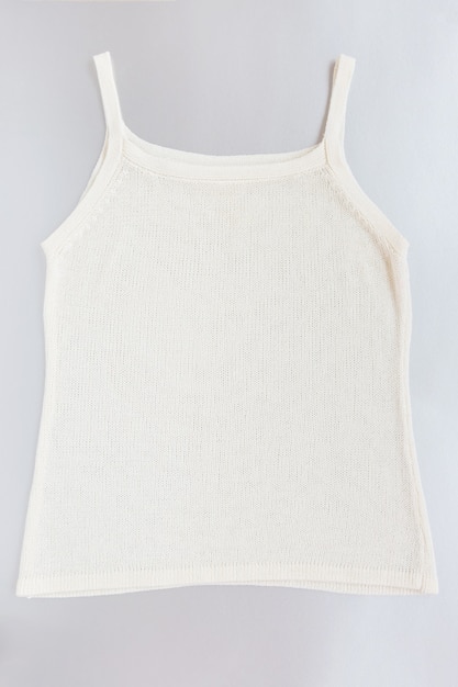 White knitted sleeveless women shirt on grey background