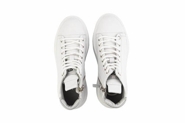 White leather sneakers Casual women's style White lacing and white rubber soles Isolated closeup on white background Top view Fashion shoes