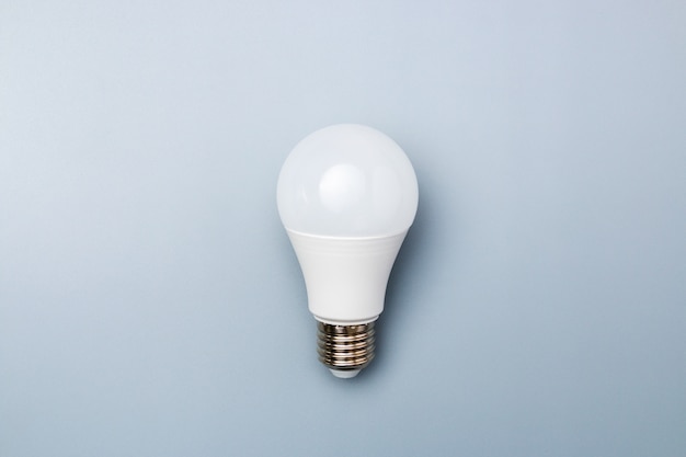 White led bulb against a grey background with copy space. energy efficiency concept