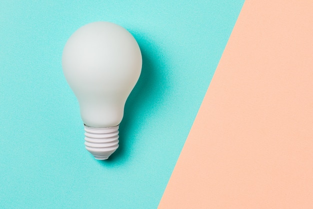 White light bulb on blue and pink background