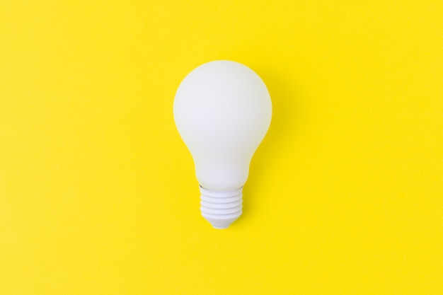 White light bulb on yellow background