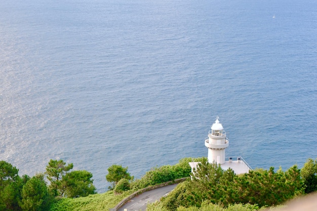 White lighthouse seen from top down against calm sea in San Sebastian Basque Country Spain