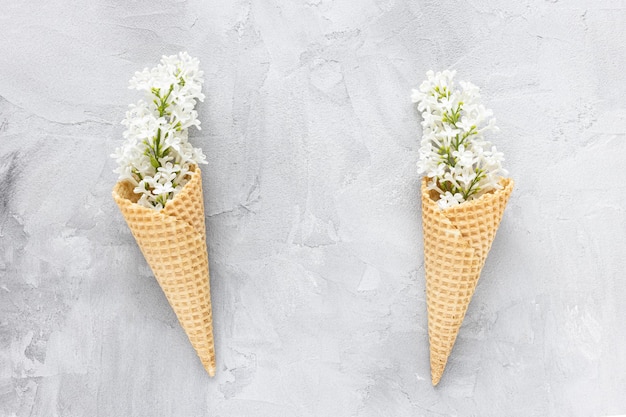 Photo white lilac flowers in ice cream cone abstract spring background