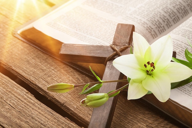 White lily, cross and holly bible book on the desk