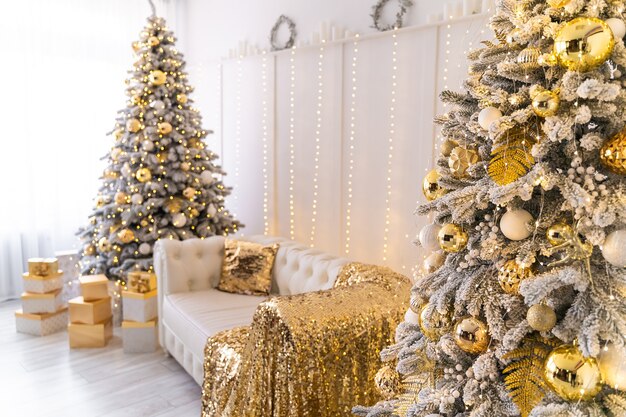 White living room interior with new year tree decorated present boxes and white sofa colden colors