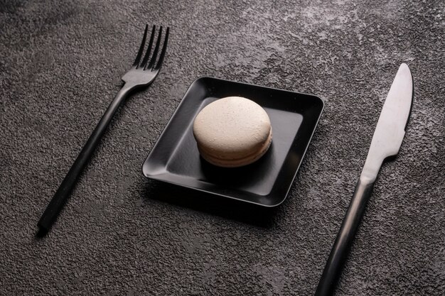 white macaroon cake in a black square plate. stylish minimalistic 