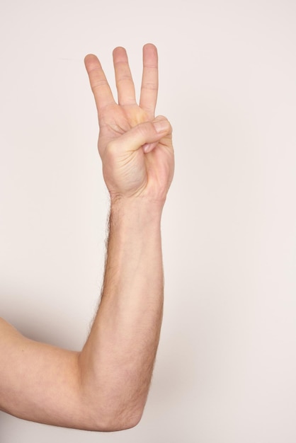 White male hand showing number three on a white isolated background.