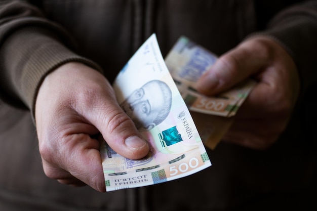 White man giving Ukrainian money bills closeup