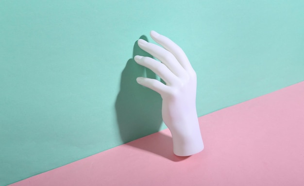 White mannequin hand on bluepink background Minimalism Trendy shadow Creative layout