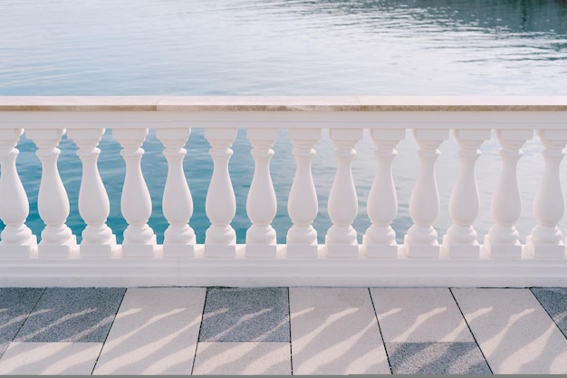 White marble balustrade on a tiled terrace by the sea