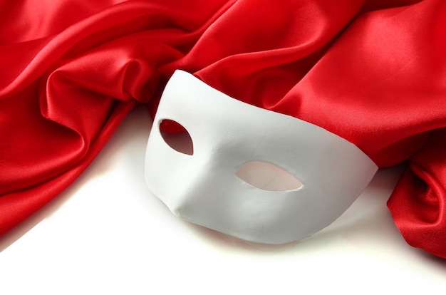 White mask and red silk fabric isolated on white