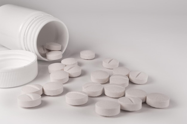 White medical pills and tablets on white background Closeup photo of medical preparations with copy space