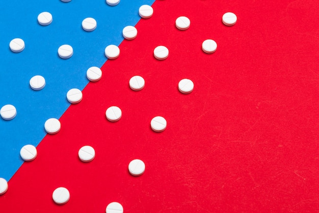 White medical pills on a two color red and blue background