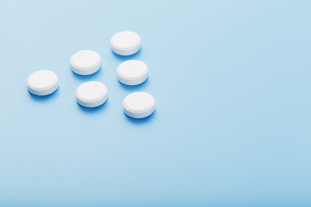 White medicinal tablets on blue