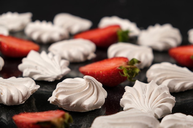 White meringue with strawberries on a black background